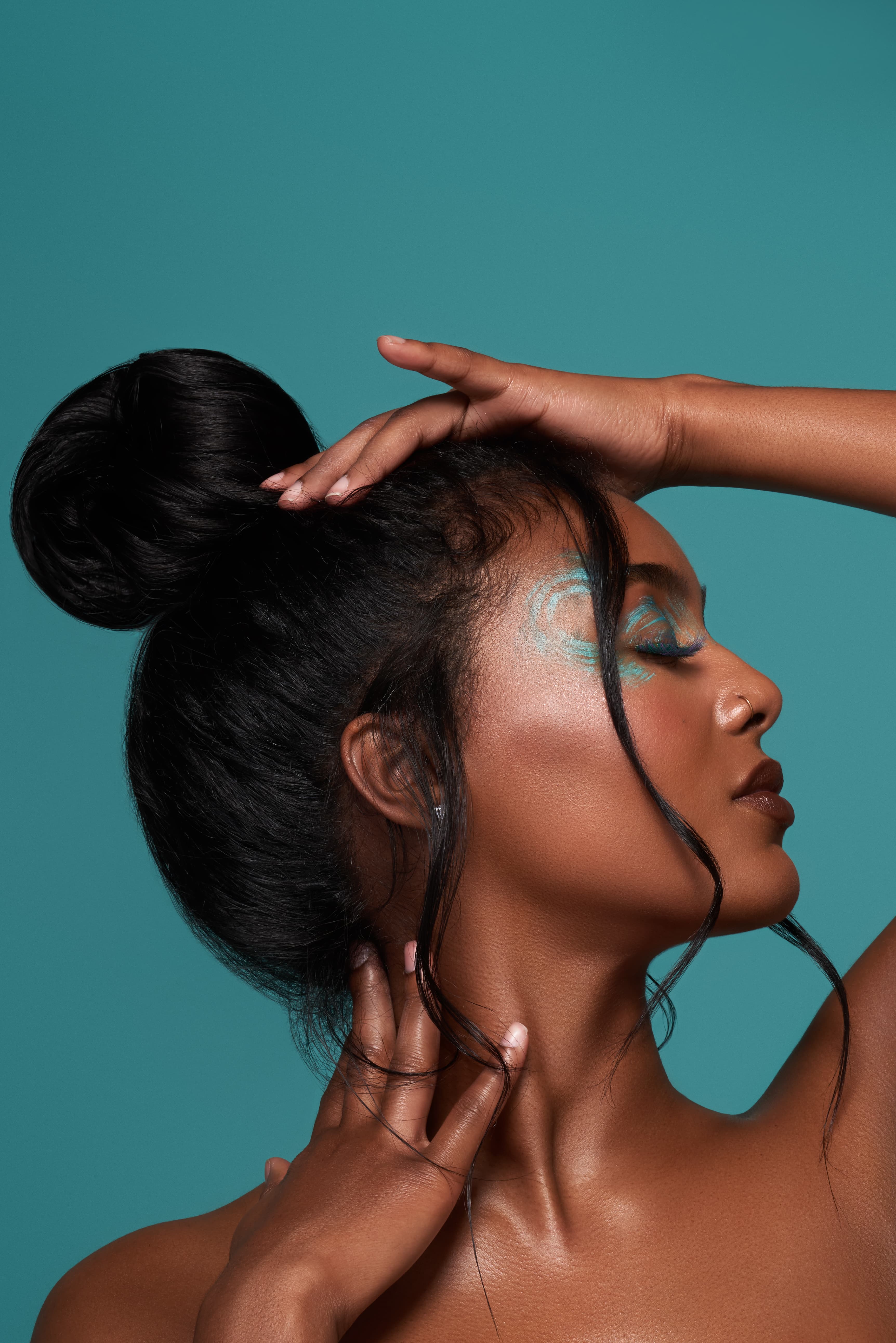 Woman lying in a circular floral composition surrounded by leaves and flowers.